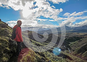 Male hiker hiking alone into the wild admiring volcanic landscape with heavy backpack. Travel lifestyle adventure wanderlust