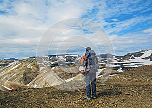 Male hiker hiking alone into the wild admiring volcanic landscape with heavy backpack. Travel lifestyle adventure wanderlust