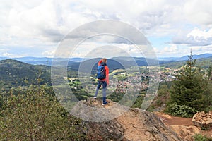 Male hiker (man) standing on mountain Silberberg and looking at panorama of Bodenmais in Bavarian Forest