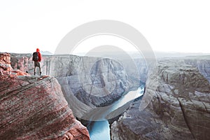 Male hiker overlooking Horseshoe Bend at sunset, Arizona, USA