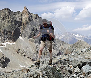 Male hiker on a rocky and dusty hiking trail in the French Alps