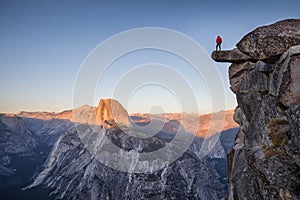 Male hiker standing on overhanging rock at Glacier Point, Yosemite National Park, California, USA photo