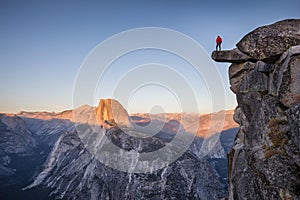 Male hiker standing on overhanging rock at Glacier Point, Yosemite National Park, California, USA