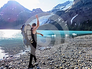 A male hiker throwing rocks into berg lake
