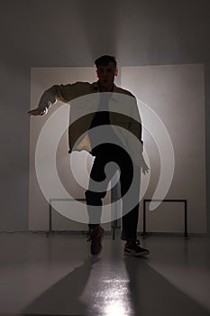 male hip-hop dancer in casual wear performing dance in studio alone, rehearsal.