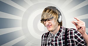 Male hipster using headphones over abstract background