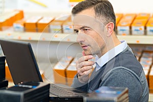 male with laptop in large warehouse