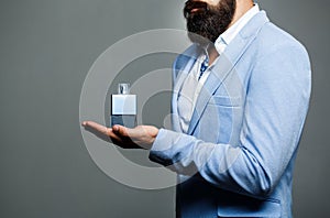 Male holding up bottle of perfume. Man perfume, fragrance. Perfume or cologne bottle and perfumery, cosmetics, scent