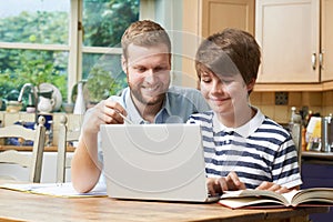 Male Home Tutor Helping Teenage Boy With Studies photo