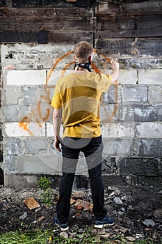 Male hooligan painting graffiti