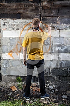 Male hooligan painting graffiti photo