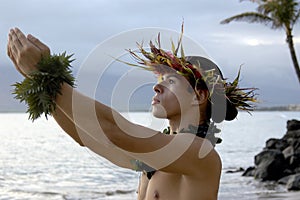Male hula dancer praying and gesturing gifts to the heavens. photo