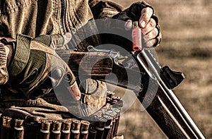 Male hunter in ready to hunt. Closeup. Hunter man. Hunting period. Male with a gun, rifle. Man is charging a hunting
