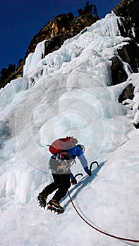 Male climber on a frozen waterfall near Pontresina in the Swiss Alps photo