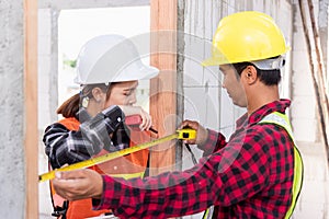 Male industrial builder workers installation process measuring wooden door with measure tape