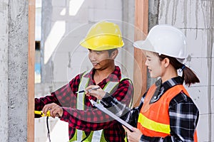 Male industrial builder workers installation process measuring wooden door with measure tape