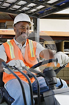 Male Industrial Worker Driving Forklift At Workplace
