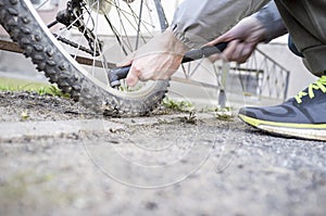 Male inflates bicycle wheel with a pump.