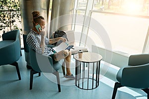 Male informal studying working documents and talking on phone