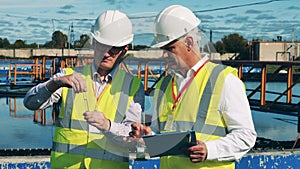 Male inspectors are analyzing a sample of wastewater