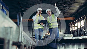 Male inspectors are talking in slow motion in the warehouse