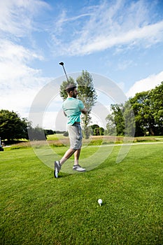 Male instructor assisting woman in learning golf