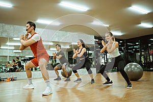 male instructor doing squats and hand defense with participants