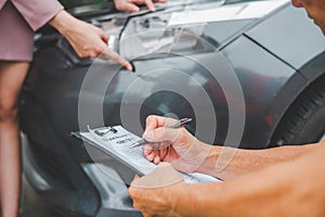 male insurance officer came to help inspect a customer's car that had an accident.