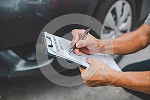 male insurance officer came to help inspect a customer's car that had an accident.