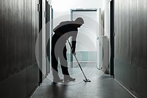 Male Janitor Cleaning Corridor