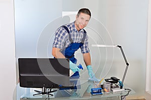 Male janitor cleaning desk