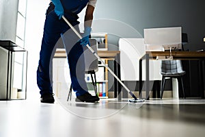 Male Janitor Mopping Floor In Face Mask