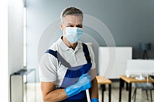 Male Janitor Mopping Floor In Face Mask