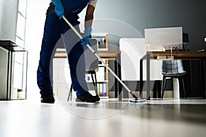 Male Janitor Mopping Floor In Face Mask photo