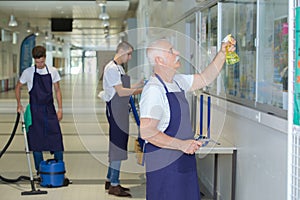 Male janitorial staff cleaning establishment photo