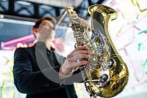 Male jazz musician playing a saxophone in a restaurant