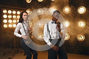 Male jazzman and female saxophonist with saxophone