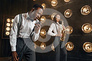 Male jazzman and female saxophonist with saxophone