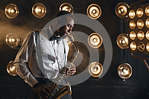 Male jazzman plays the saxophone on stage