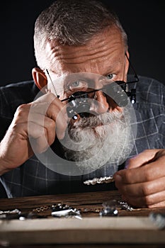 Male jeweler evaluating diamond brooch