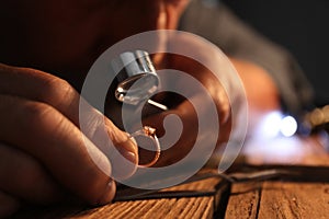 Male jeweler evaluating diamond ring, closeup view