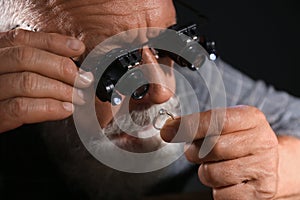 Male jeweler evaluating diamond ring in workshop