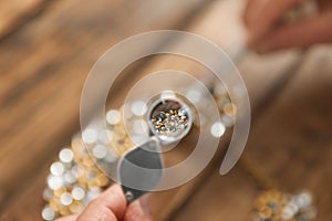 Male jeweler evaluating necklace at table in workshop