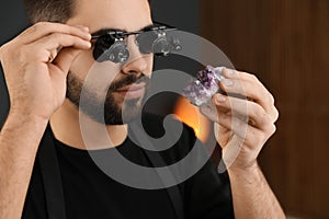 Male jeweler evaluating semi precious gemstone in workshop