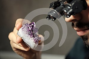 Male jeweler evaluating semi precious gemstone in workshop