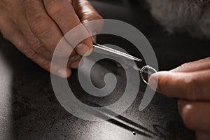 Male jeweler examining diamond ring in workshop