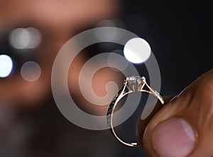 Male jeweler examining diamond ring in workshop