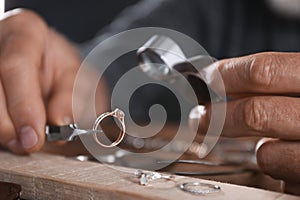 Male jeweler examining diamond ring in workshop, closeup
