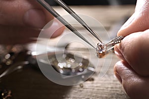 Male jeweler examining diamond ring in workshop, closeup view