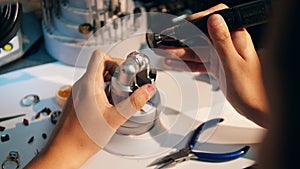 Male jeweller polishes a ring with red gemstone. A goldsmith in jewellery working with ring.